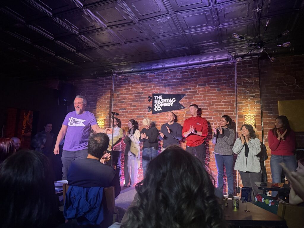 Phil Ratcliff and classmates on stage during an improv showcase at The Hashtag Comedy Co. in Columbus