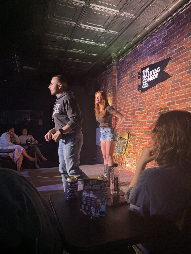 Two improvisers mid-scene on stage at The Hashtag Comedy Co.