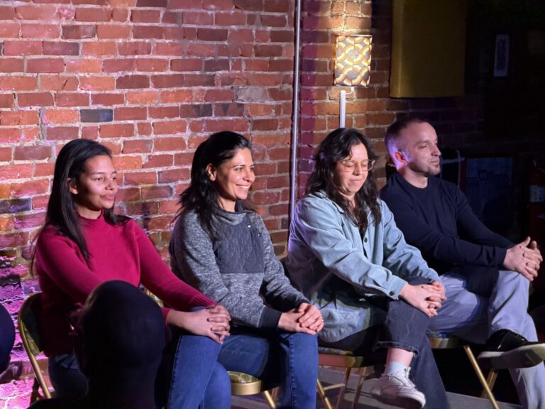 Improv classmates sitting stage-side waiting for their turn