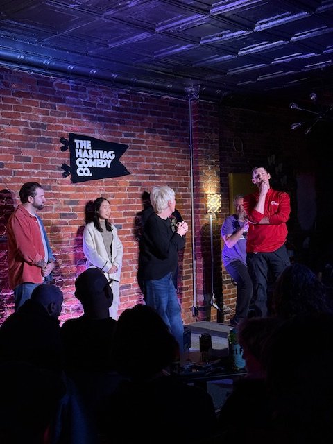 Improv performers in a scene on stage at The Hashtag Comedy Co.