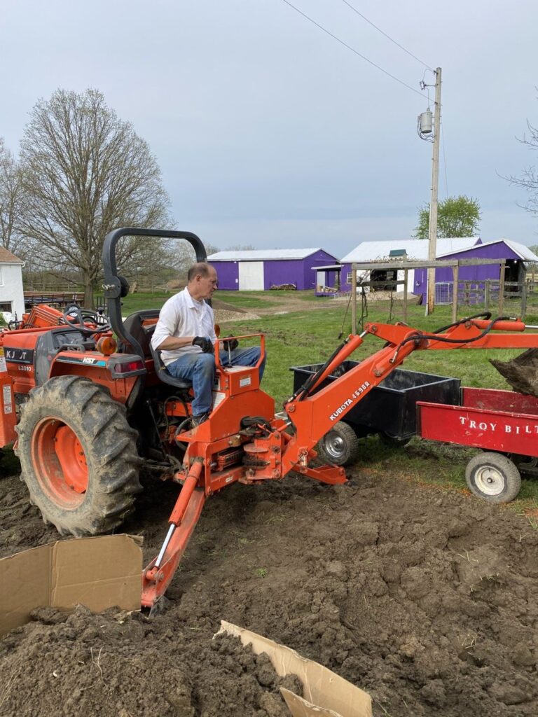 Phil digging with the backhoe at the farm